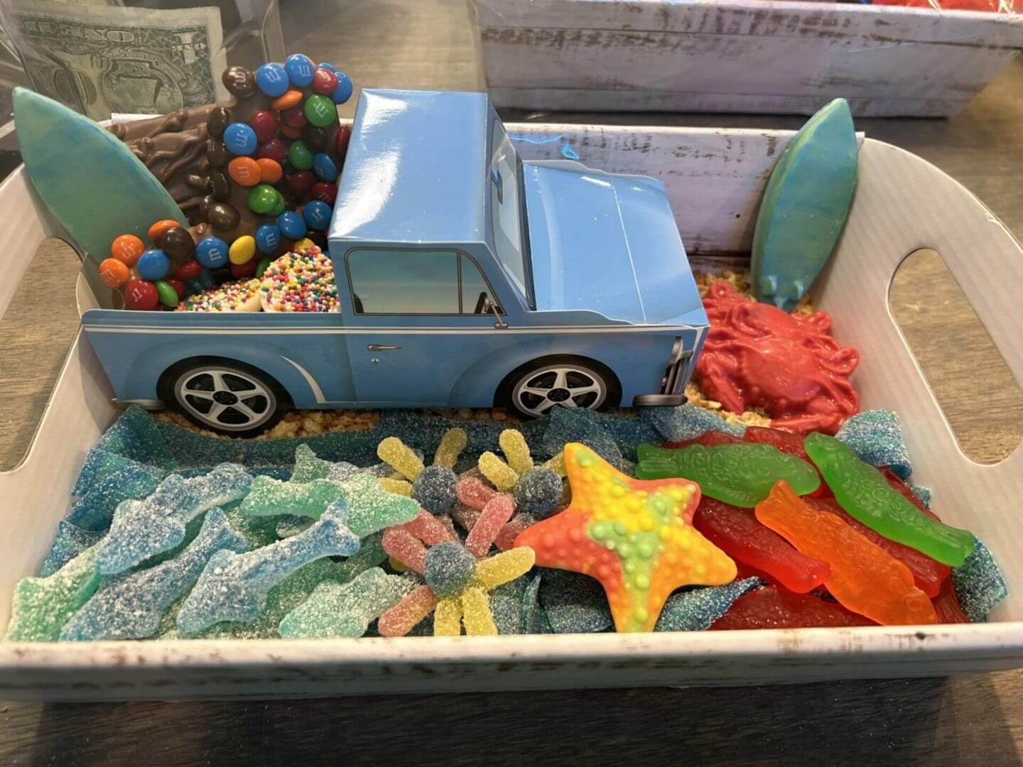 A box of candy with a truck and surfboard in it.