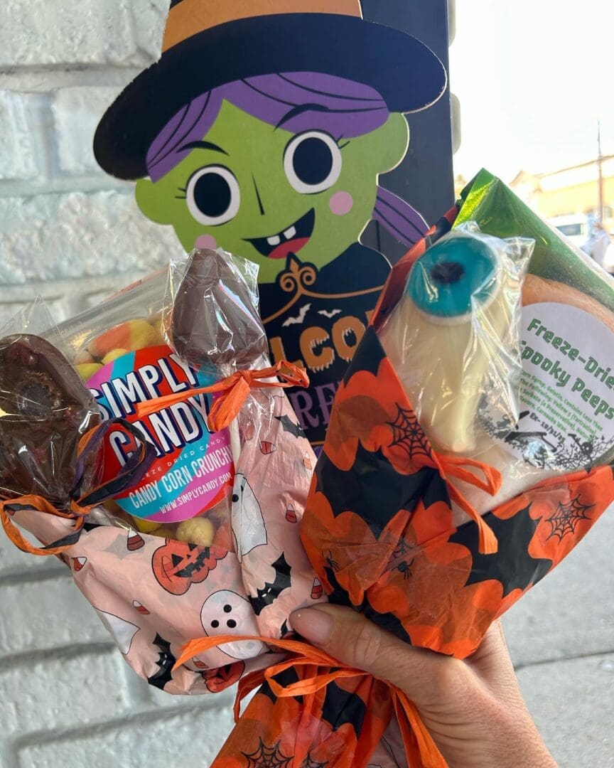 A hand holding some candy and halloween decorations