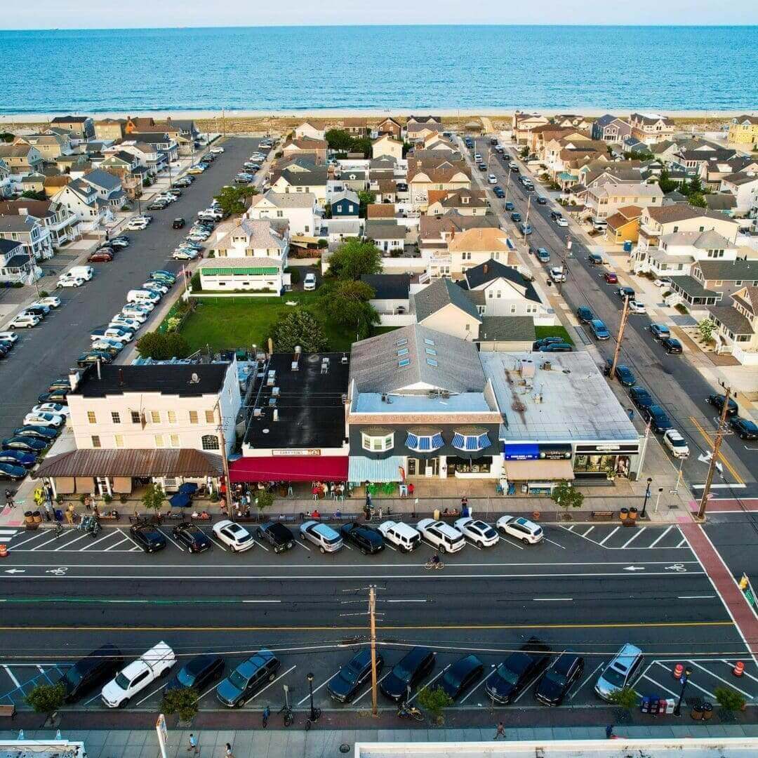 An aerial view of a street with cars parked on the side.