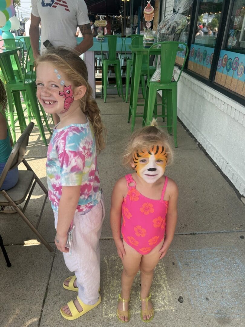 Two little girls with face paint on their faces.