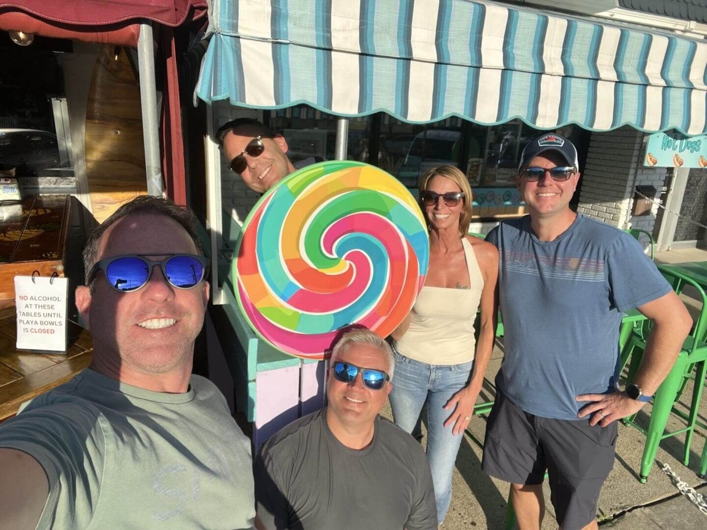 A group of people standing around a giant lollipop.