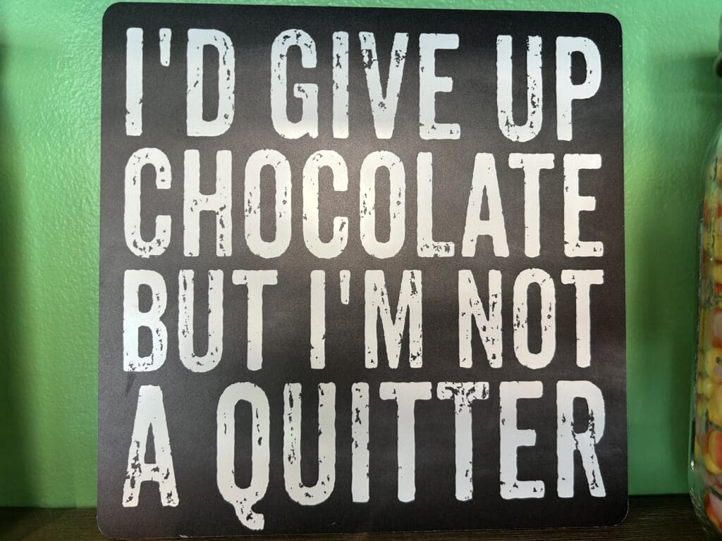 A sign that says i 'd give up chocolate but i 'm not a quitter.