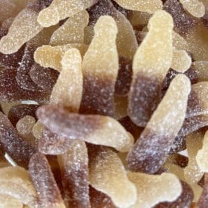 Close-up of cola-flavored gummy candies covered in sugar.