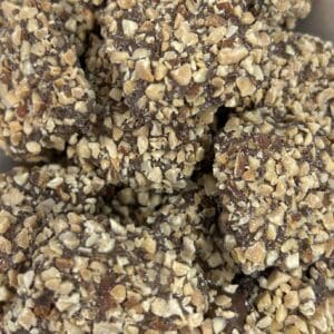 Close-up of chocolate-covered treats coated with chopped nuts.