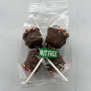 Chocolate-covered nut-free cake pops with sprinkles, packaged together.