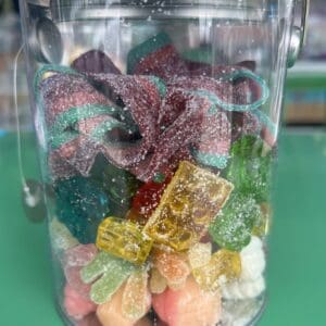 Colorful gummy candies in a glass jar.