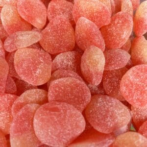 Close-up of red gummy candies coated with sugar.