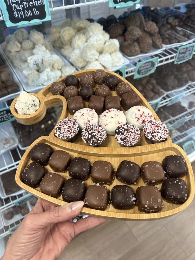 Assorted chocolate and cream-filled dessert balls on wooden trays.