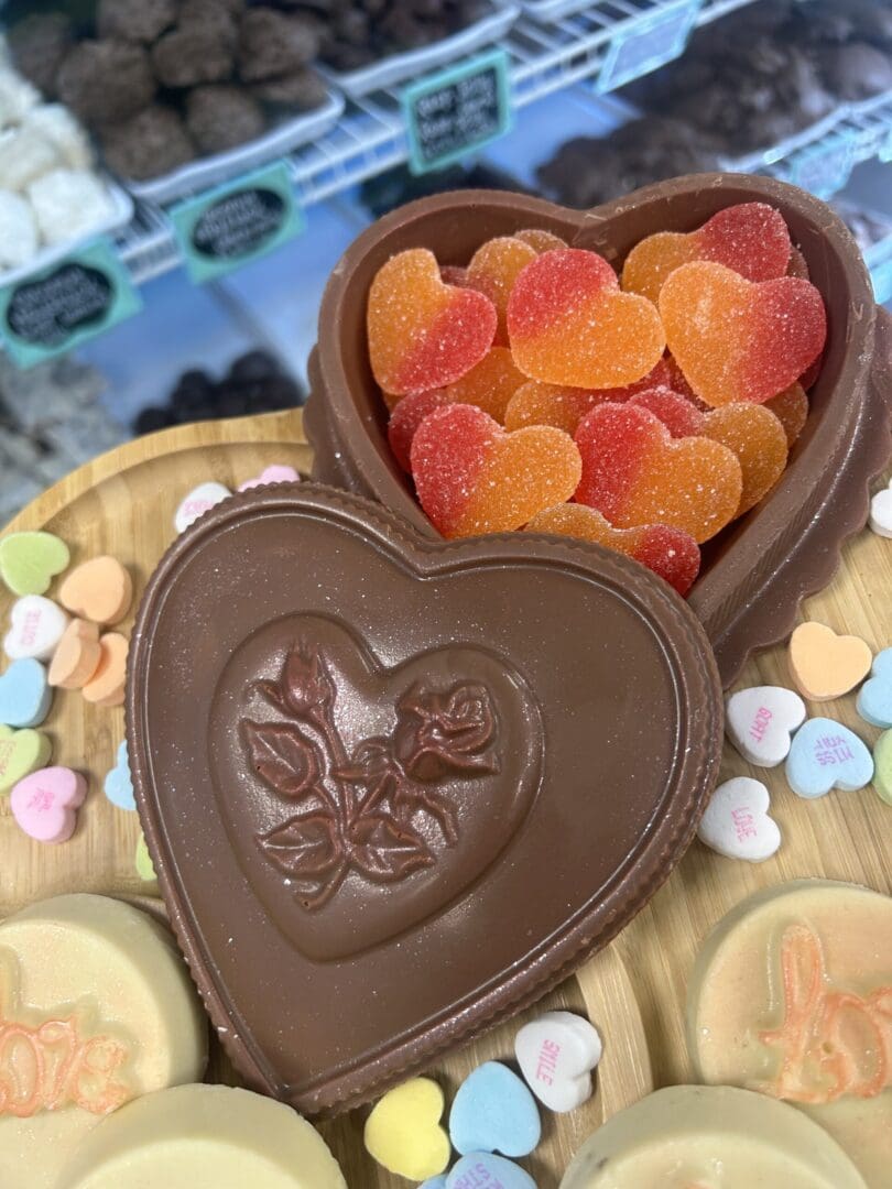 Heart-shaped chocolate box with gummy hearts inside.