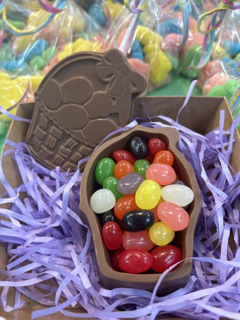 A chocolate Easter egg filled with colorful jelly beans inside a festive basket.
