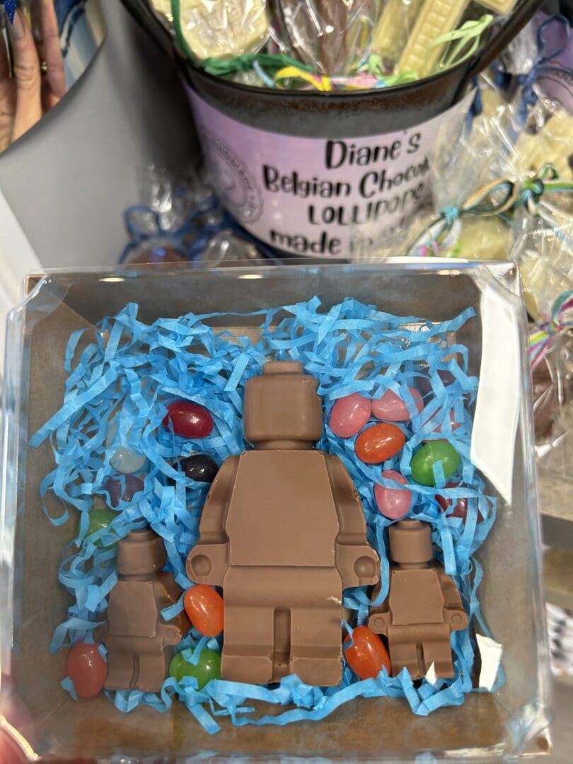 Chocolate figures shaped like a person and a dog in a decorative box.