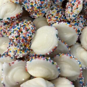 Close-up of white chocolate treats covered with colorful sprinkles.
