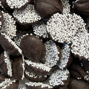Chocolate-covered candies with white sprinkles.