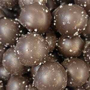 Close-up of chocolate-covered round treats with a textured coating.