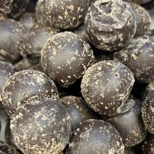 Close-up of dark chocolate-covered round treats with a dusting of powder.