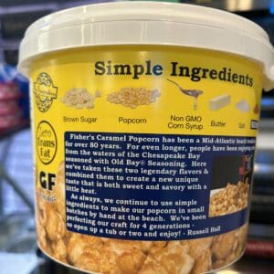 A container of gluten-free caramel popcorn with a detailed ingredient label.