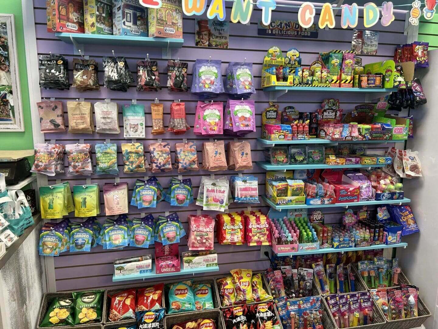 A colorful candy store shelf filled with various sweets and snacks.