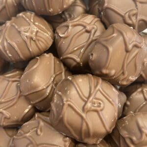 Close-up of milk chocolate candies with decorative drizzle.