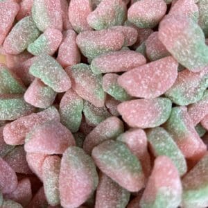 Close-up of pink and green gummy candies shaped like strawberries.