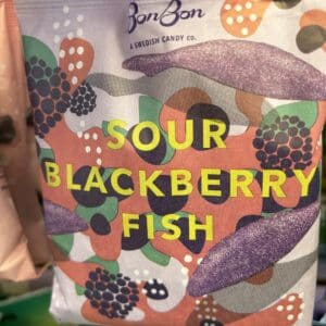 Colorful packaging for sour blackberry fish candy with berry illustrations.