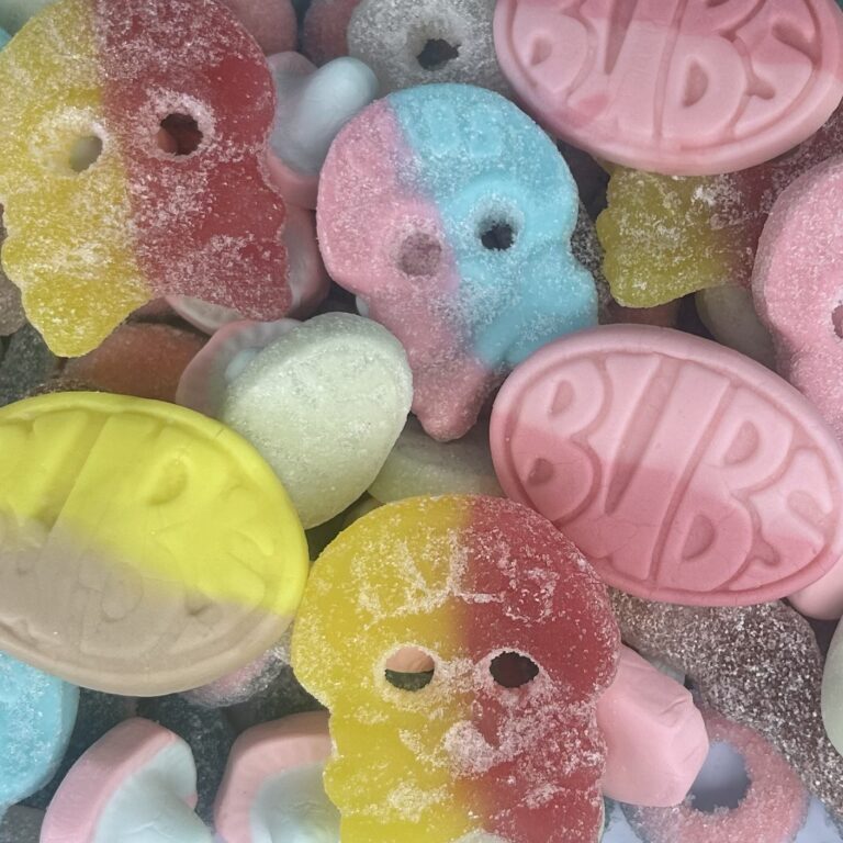 Colorful gummy candies shaped like bears and ovals with fruit flavors.