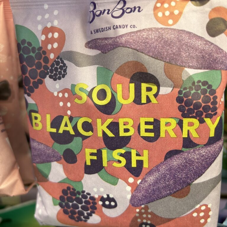 Colorful packaging for sour blackberry fish candy with berry illustrations.